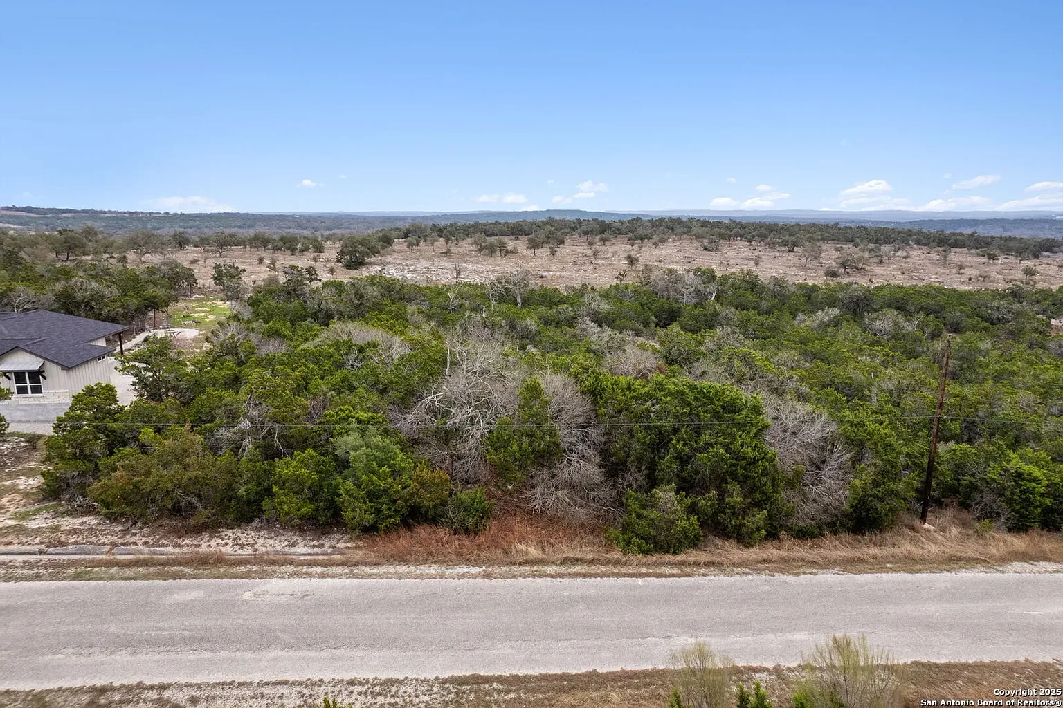 Treed acreage with a caliche road running through it