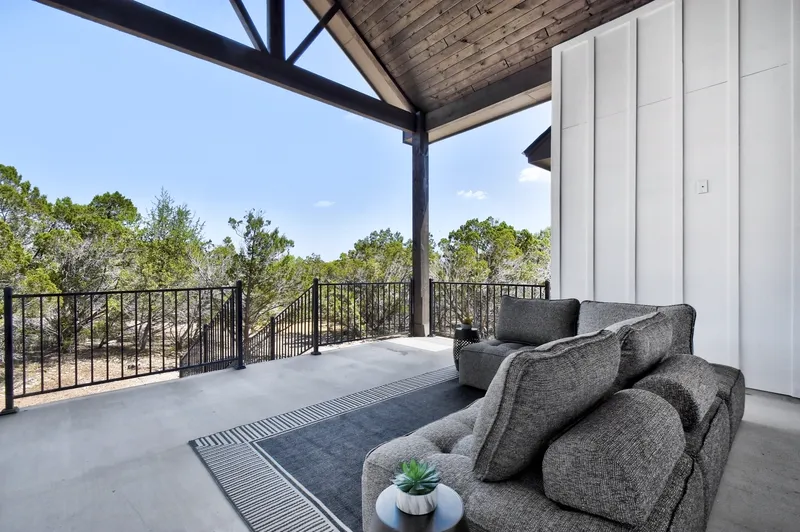 Covered outdoor living area with seating under a vaulted porch ceiling