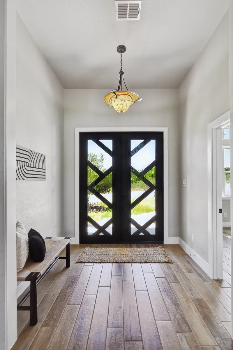 Entry hall with custom dark double doors and wide-plank wood floors