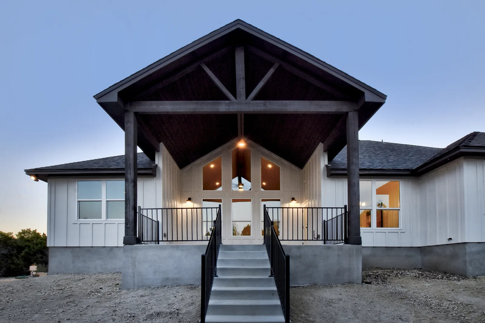 Timber-framed front porch of a Vaughn custom home lit at dusk