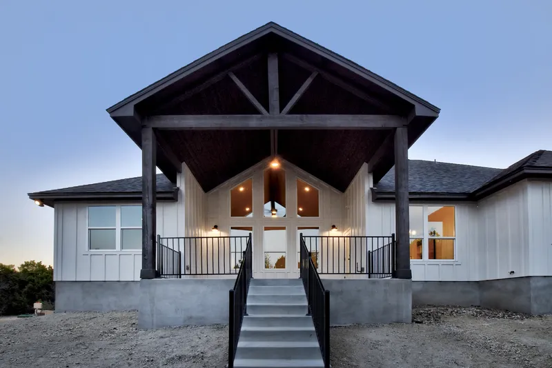 Timber-framed front porch of a Vaughn custom home lit at dusk