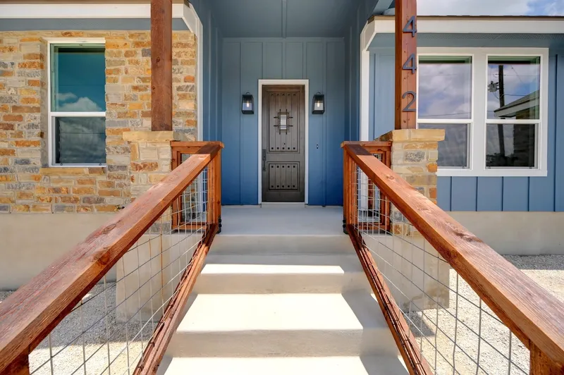 Front entry with stone columns, board-and-batten siding and a timber porch rail