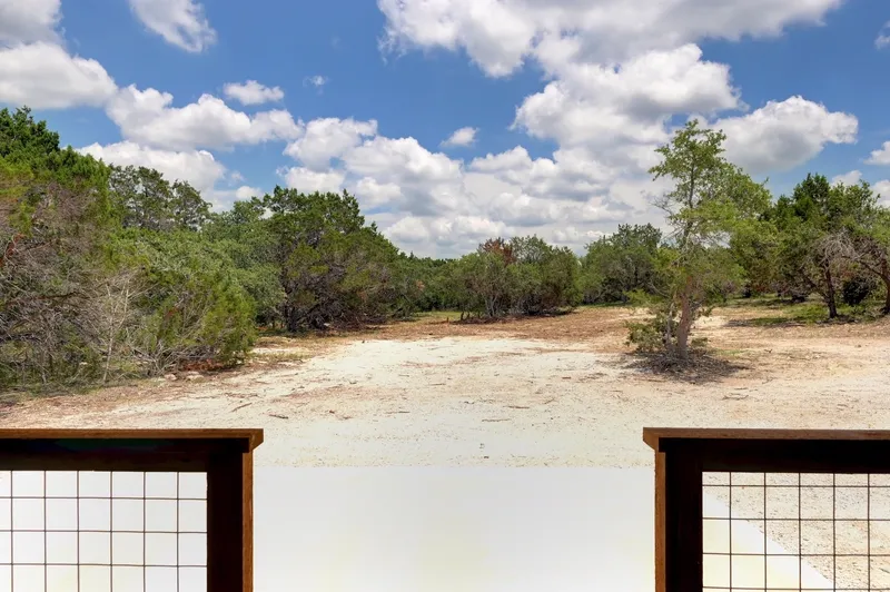 View from the porch across cleared ground to the oak and juniper beyond