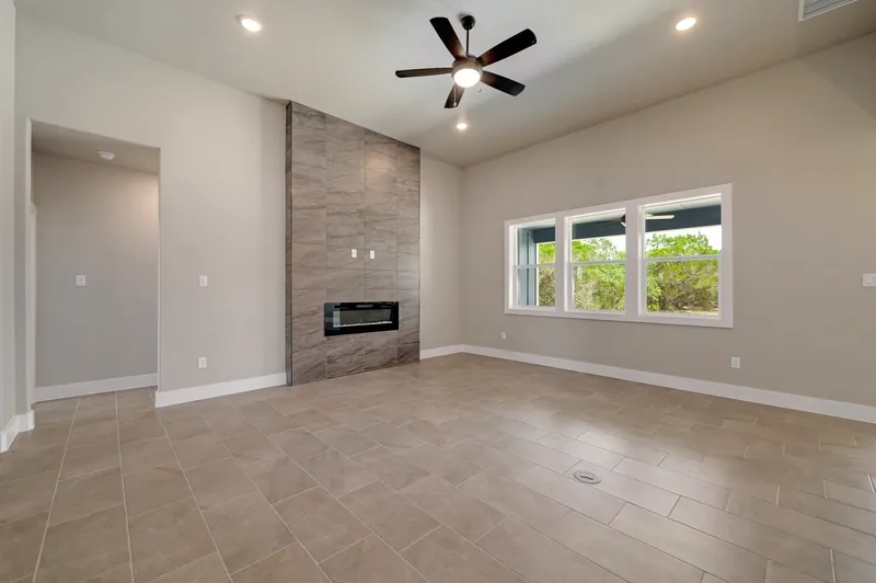 Living room with a linear fireplace set into a full-height wood-look tile wall