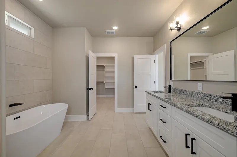 Freestanding tub beside the double vanity in the primary bathroom