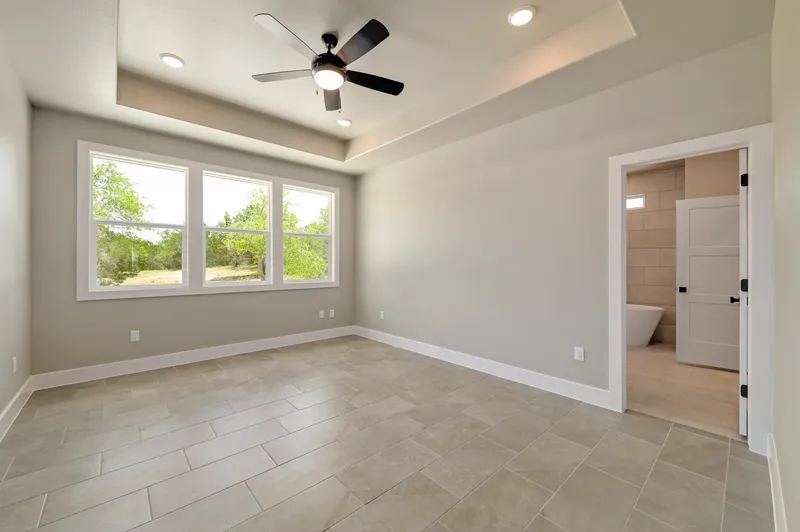 Primary bedroom with a tray ceiling and a door through to the ensuite bathroom