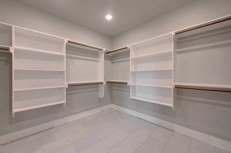 Walk-in closet fitted out with shelving and hanging rails on three walls