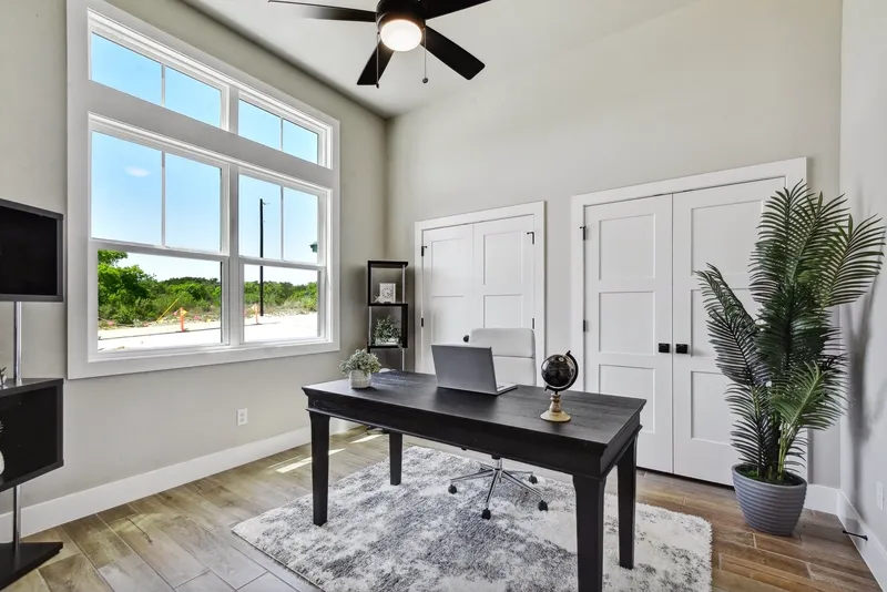 Home office with a wall of windows and a ceiling fan