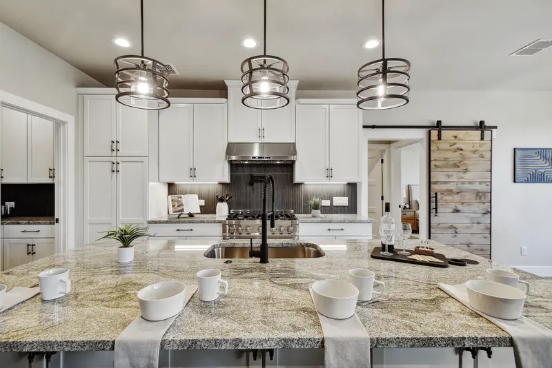 Granite kitchen island with a sliding barn door to the pantry