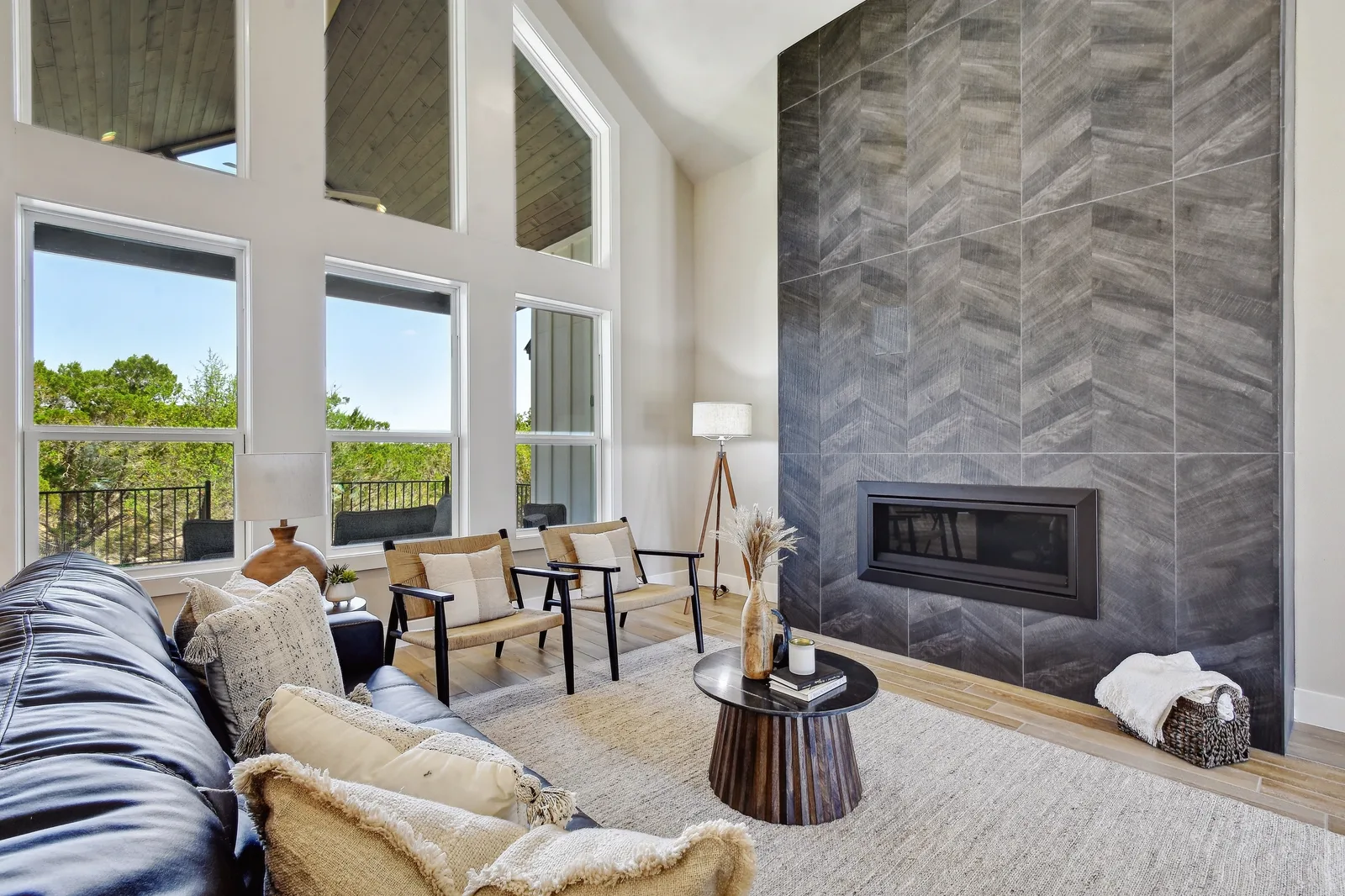 Living room with a floor-to-ceiling chevron tile fireplace wall beside a two-story window wall