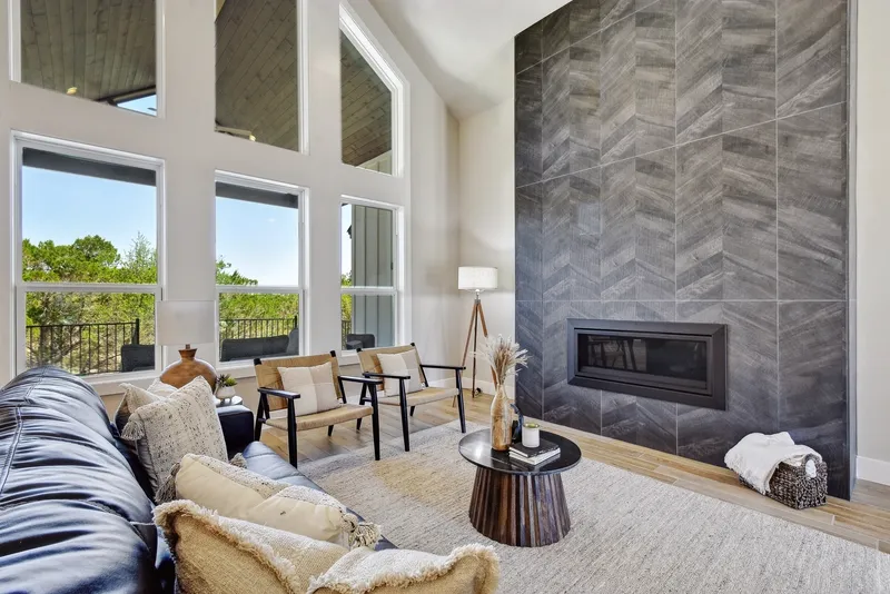 Living room with a floor-to-ceiling chevron tile fireplace wall beside a two-story window wall